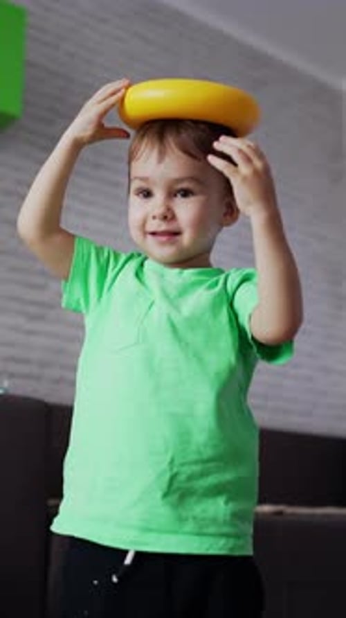 Niño sonriente jugando en su habitación. Niño juguetón divirtiéndose con juguetes. Ángulo de visión bajo.