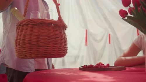 Man Brings Champagne to Romantic Outdoor Picnic Setting