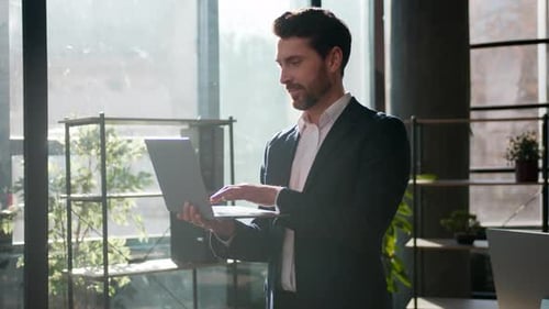 Smiling Successful Caucasian Businessman Typing Laptop Office Looking at Camera Confident