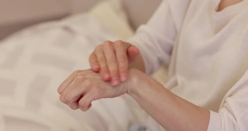 Female Hands Use Cream or Lotion in Bedroom