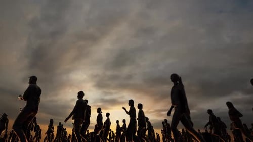 Silhouettes of Diverse People Walking Against Dramatic Sunset Sky