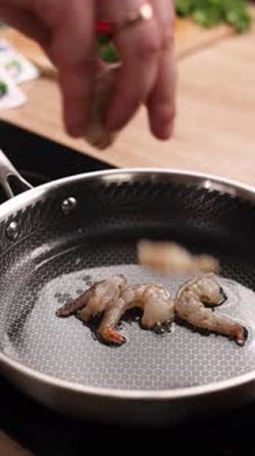 A chef prepares a shrimp dish in the kitchen. Close-up