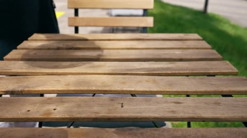 Closeup in Restaurant on the Street Over a Wooden Table the Chef Holds a Blue Plate with a Warm