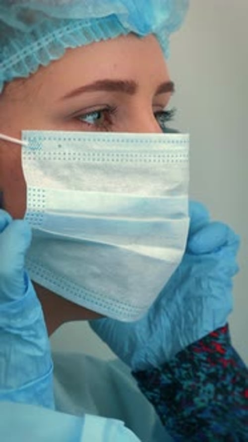 Woman Removes Face Mask in Hospital Setting