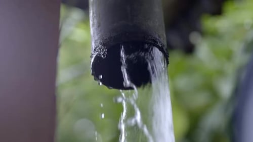 Heavy rain water gushing out of gutter