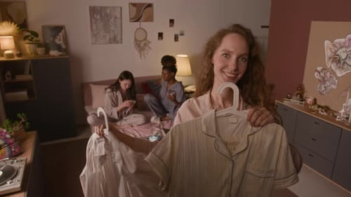 Smiling Woman Holding Pajamas with Friends Relaxing
