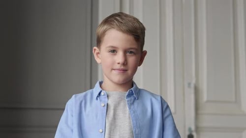 Smiling Boy Poses with Arms Crossed Indoors