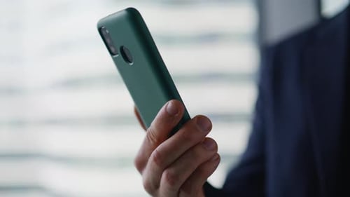 Executive Fingers Tapping Smartphone Browsing Application in Office Closeup