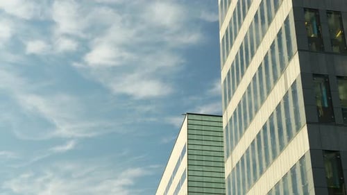 Close-up of a modern office building facade with reflective windows and architectural details.