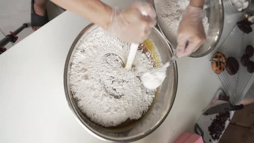 Pastry Chef Adding And Mixing Flour Into Dough Mixture. Making Cookies In The Kitchen. overhead