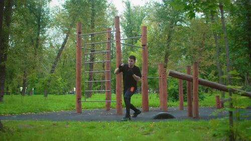 Athlete Practicing Agility and Strength in Outdoor Park Setting Individual Performing Fitness Drills