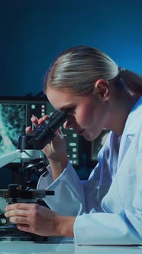 Woman Scientist Using Microscope in Laboratory Setting