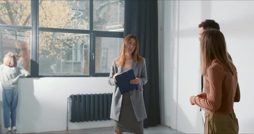 BUYING NEW APARTMENT Beautiful Real Estate Agent Woman Talks to Young Family with Child in Big Light