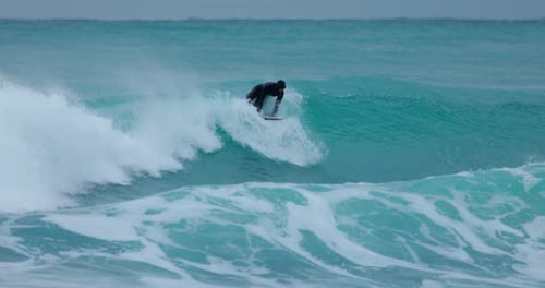 Surfer Rides on Wave in Cold Ocean Winter Surfing on Perfect Waves