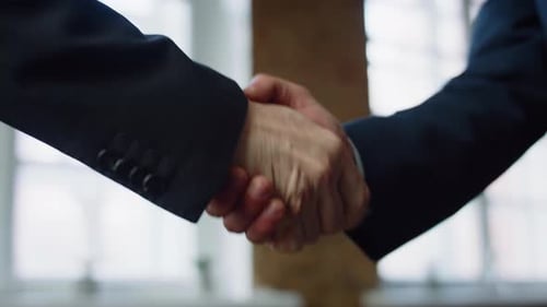 Closeup Men Shaking Hands at Office Meeting. Unrecognizable Business Partners in Elegant