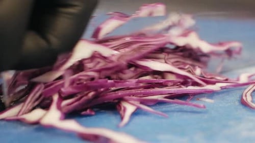 Chef Slices Purple Cabbage on Cutting Board