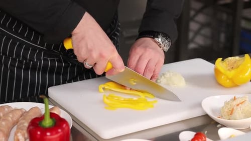 Chef Dicing Yellow Pepper on Cutting Board