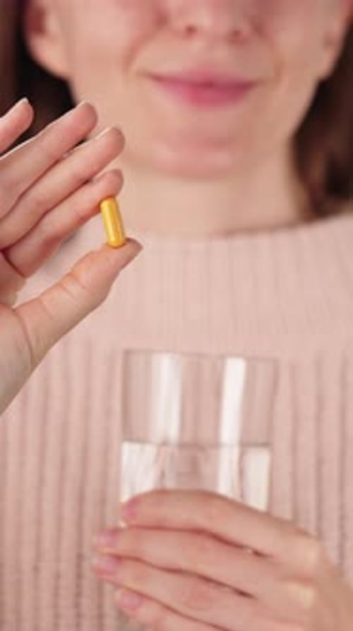 Woman Holding Turmeric Capsule With Water Daily Curcumin Supplement