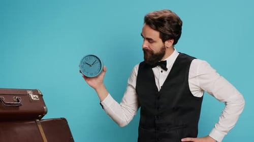 Man Holding Clock Next to Luggage