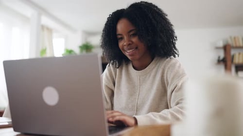Woman Working on a Laptop at Home Smiling