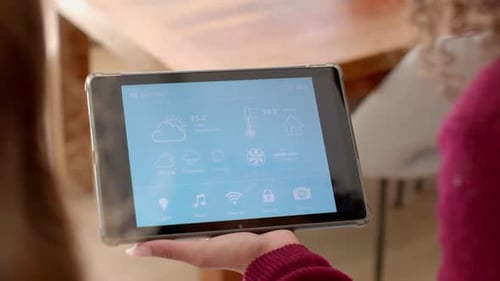 Sosteniendo una tableta, mujeres gestionando juntas la configuración inteligente del hogar en la sala de estar
