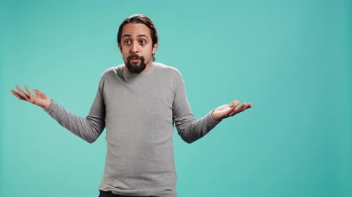 Bearded Man Shrugs in Confusion in Front of Blue