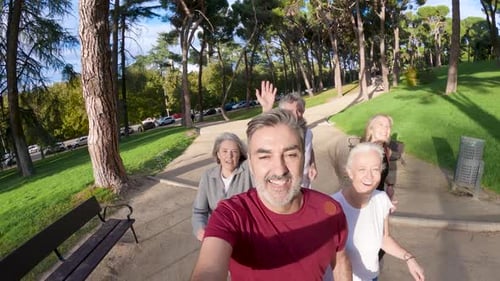 Cheerful Group of Mature Friends Jogging in a Park Together