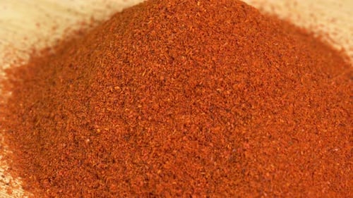 La
especia de pimentón en polvo gira sobre fondo de madera. Condimento seco: pimentón. Especias y hierbas para cocinar