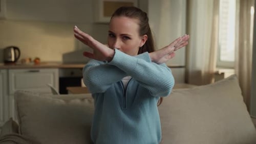 Portrait of a Serious Brunette Woman Dressed in a Blue Sweatshirt Arms Crossed Over Her Chest