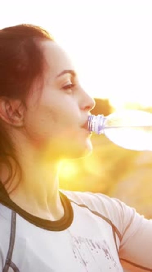 Fit Woman Drinking Water at Golden Hour
