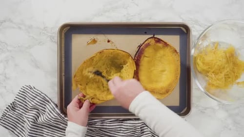 Woman Shreds Cooked Spaghetti Squash with Fork