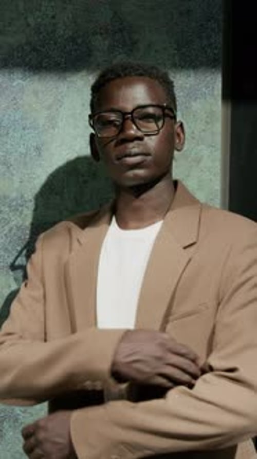 Street Portrait of Confident Black Young Businessman Crossing Arms