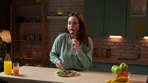 Woman Enjoys Healthy Salad in Home Kitchen