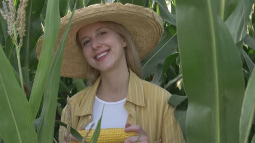 Happy Woman Holding Corn in a Rural Field