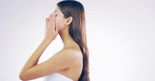 4k video footage of a beautiful young woman touching her flawless skin in the studio