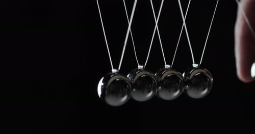 Kugeln im Newtonschen Pendel treffen aufeinander und zeigen das Gesetz zur Energieeinsparung