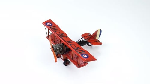 Red Model Airplane Stationary on White Background