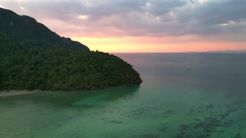 Sunset cloudy sky tropical island, boats in turquoise sea. Marvelous aerial view flight drone