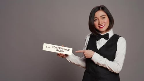 Woman Points to Conference Room Sign