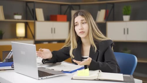 Woman at Desk Talking During Video Call