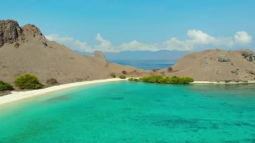 Turquoise Sea With Shallow Waters At Pink Beach On Komodo Island In Indonesia. drone pullback shot