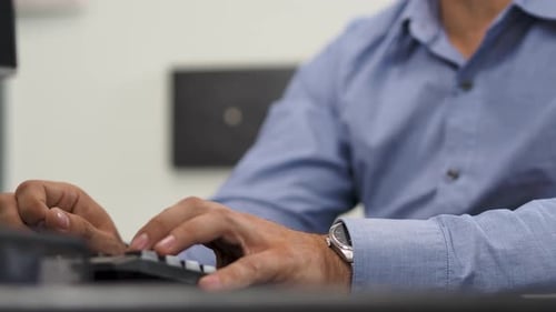 Businessman typing on computer keyboard working in office.
