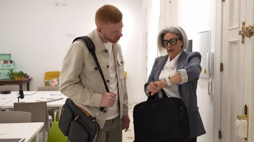 Mature Businesswoman and Young Male Colleague Arriving at Coworking Office