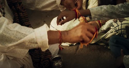 Close Up Authentic Footage of Hindu Priest Tying a Mauli Thread Around a Male Kid's Wrist in