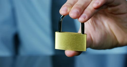 Hand Holding Gold Padlock Close Up