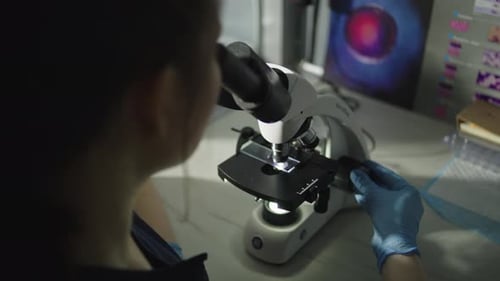 Un médecin professionnel examine un microscope dans un laboratoire