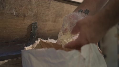 close up side, french baker’s hand is touching and feeling tasty wheat flour