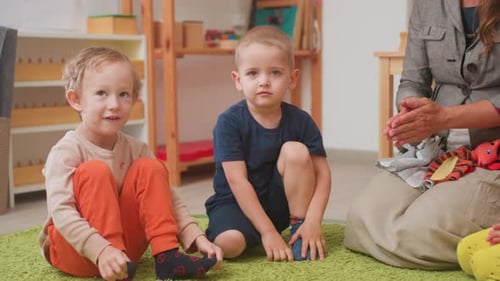 Children sitting on the floor in a classroom.