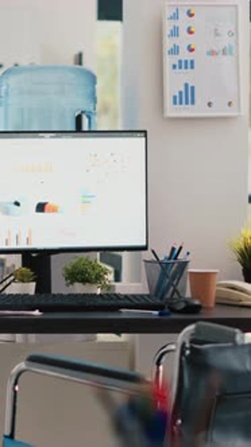 Vertical Video Wheelchair in Inclusive Office for Workers and Displays Showing Marketing Charts