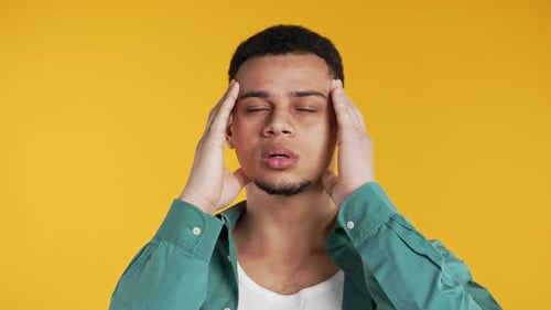 Stressed Young Adult Holding Head in Pain